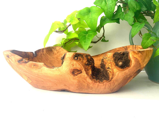Rustic oval fruit bowl made from olive wood light brown and a live bark edge 